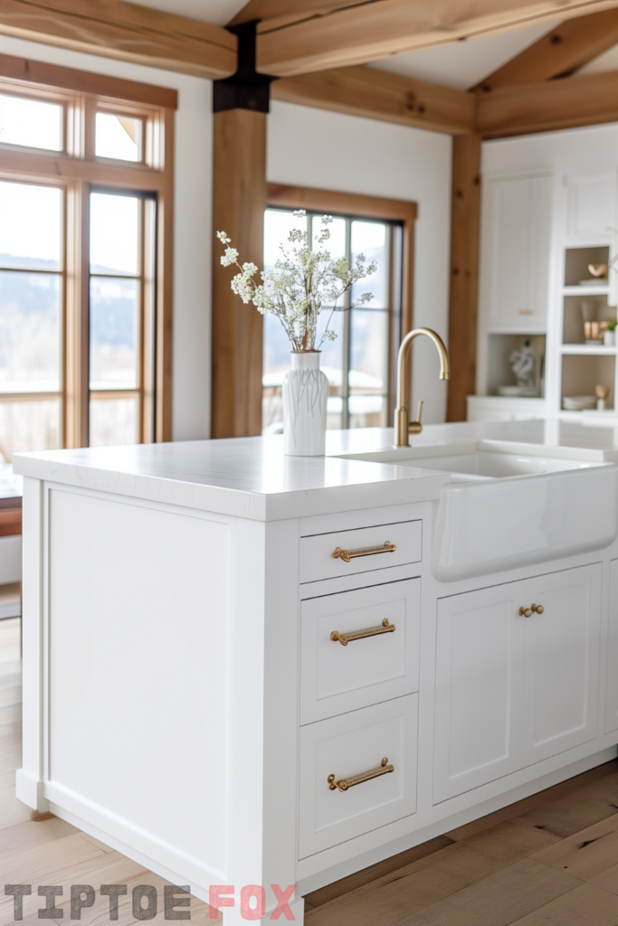 open white kitchen gold hardware white island wood floor antiqued gold faucet white cabinets white countertops wood beams double bowl white farmhouse sink